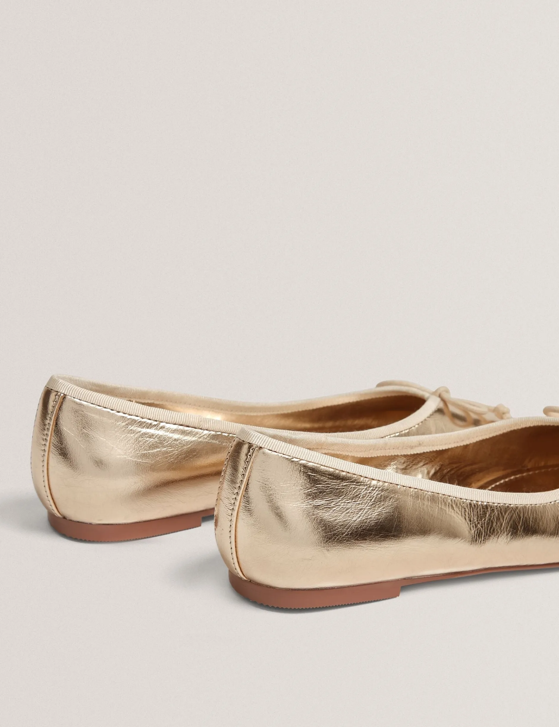 Ballerinas aus Metallic-Leder mit Schleife