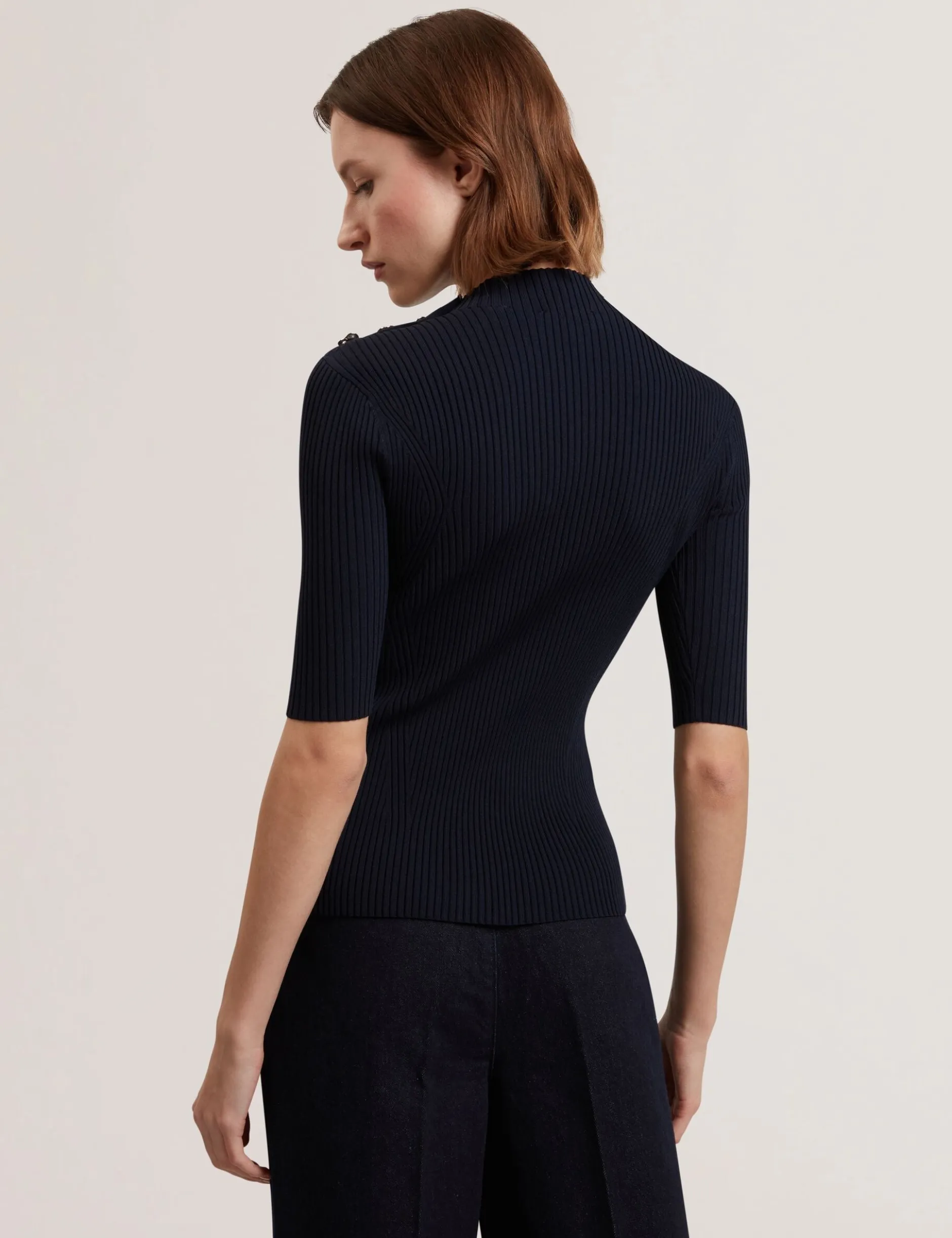 Figurbetontes Stricktop mit Rosenknopfdetails