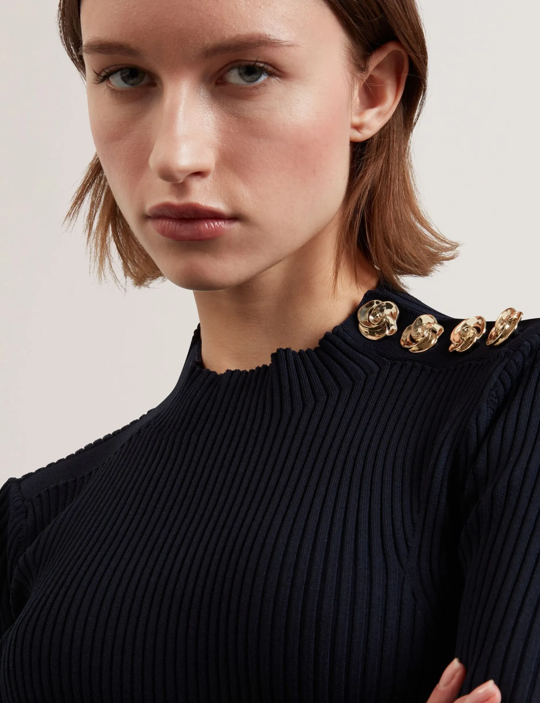 Figurbetontes Stricktop mit Rosenknopfdetails